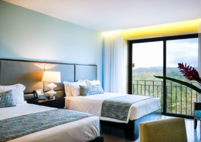 A two queen bed hotel room in Costa Rica with a view of the mountains