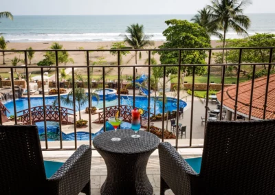 A hotel balcony overlooking the beach and pool at Crocs Resort in Costa Rica